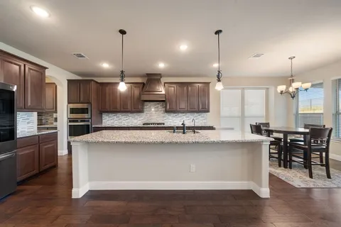 a large kitchen with kitchen island a sink and a stove top oven