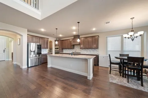 a kitchen with a refrigerator and a dining table