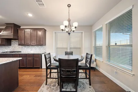 a dining room with granite countertop a table chairs and a chandelier
