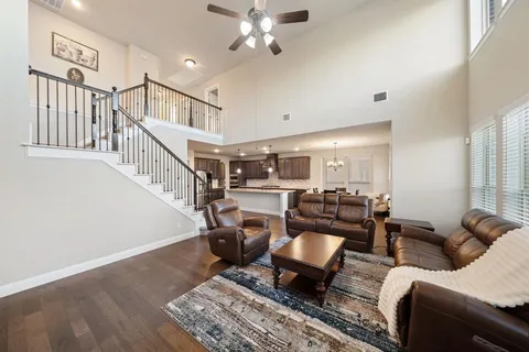 a living room with furniture and a ceiling fan