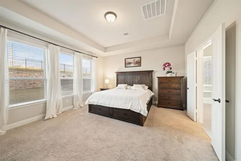 a bedroom with a large bed and a window
