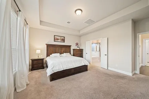 a spacious bedroom with a bed and a lamp