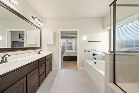 a bathroom with a tub sink and mirror