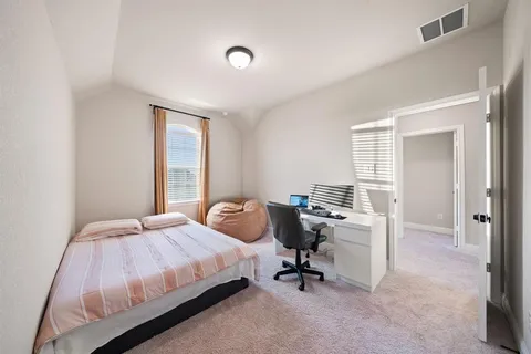 a bedroom with a bed and a desk
