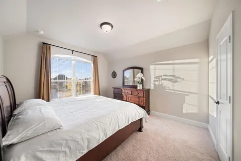 a bedroom with a large bed and a window