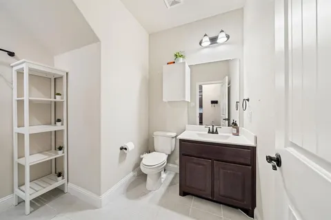 a spacious bathroom with a toilet sink and mirror