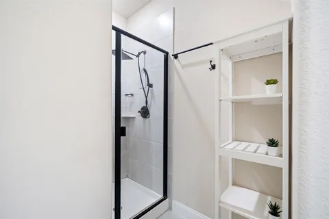 a bathroom with a granite countertop shower and a sink