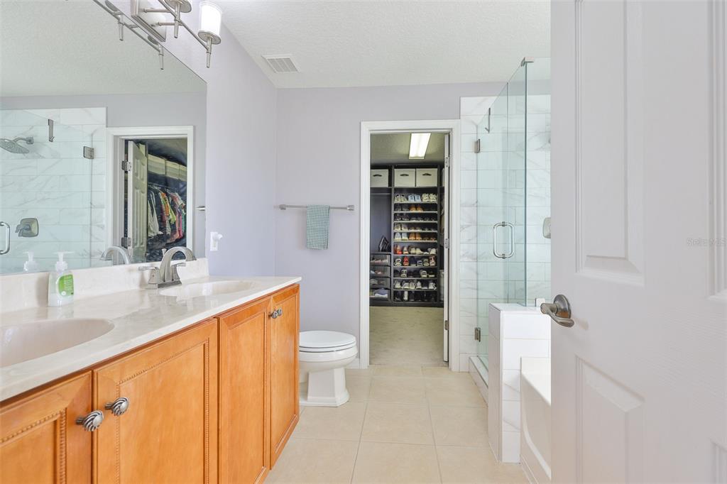 5409 Hammock View Lane Apollo Beach, FL 33572 - Photo 29 of 68 a bathroom with a granite countertop sink a toilet and shower