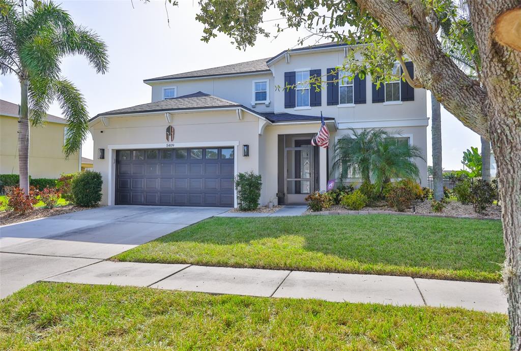5409 Hammock View Lane Apollo Beach, FL 33572 - Photo 42 of 68 a front view of a house with a yard and garage