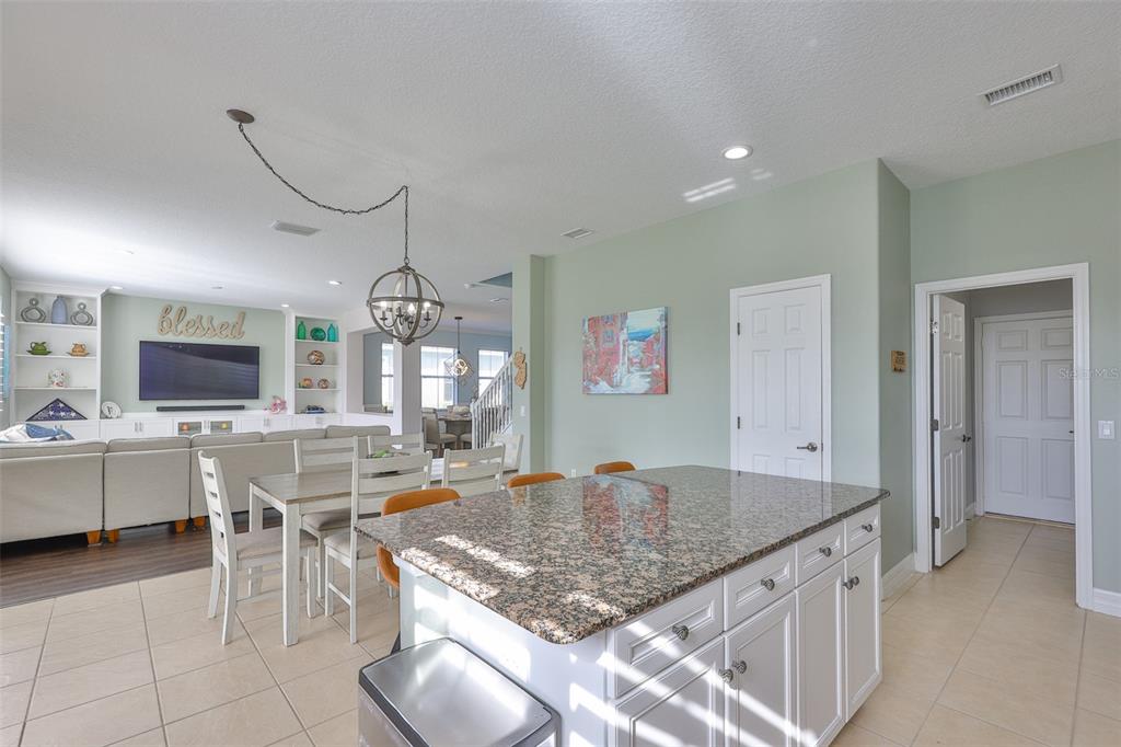 5409 Hammock View Lane Apollo Beach, FL 33572 - Photo 9 of 68 a kitchen with stainless steel appliances granite countertop a stove top oven a sink a dining table and chairs