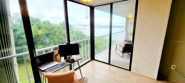 a view of work space with furniture and floor to ceiling window