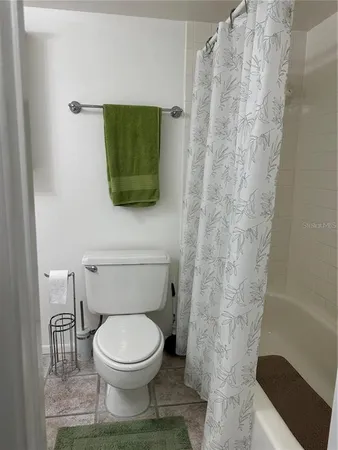 a bathroom with a toilet and a shower curtain