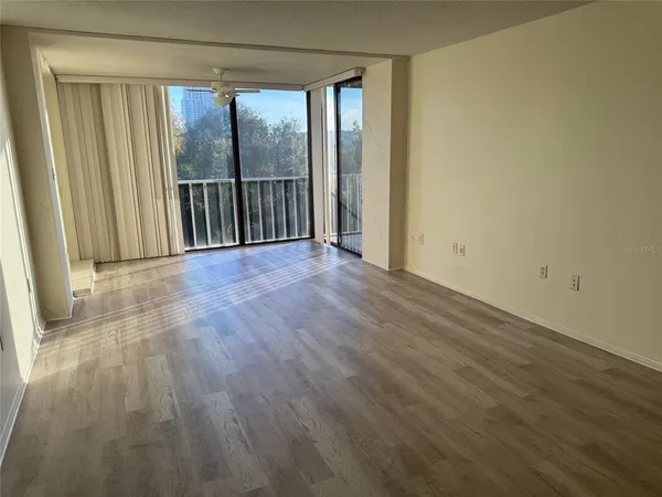 a view of a room with wooden floor and glass door