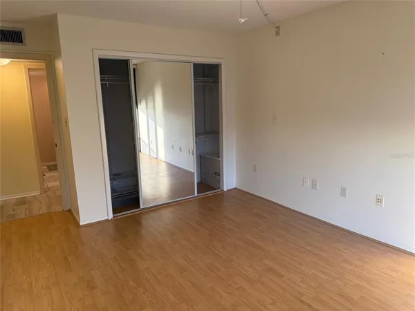 an empty room with closet and windows
