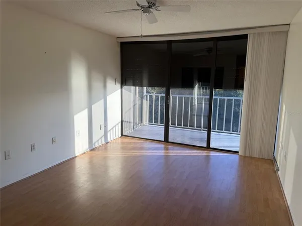 a view of a livingroom with wooden floor and a ceiling fan