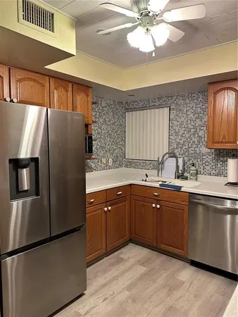 a kitchen with stainless steel appliances granite countertop a refrigerator sink and cabinets