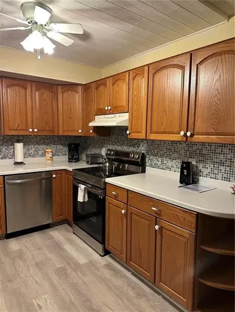 a kitchen with granite countertop a sink stainless steel appliances and cabinets
