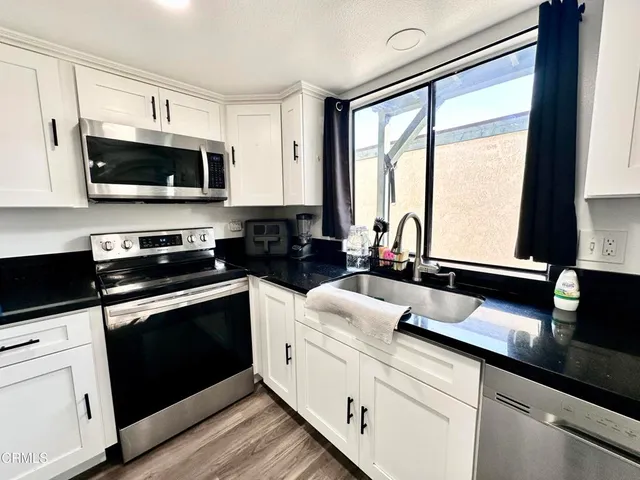 a kitchen with stainless steel appliances white cabinets and a sink