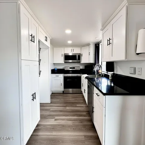 a kitchen with stainless steel appliances a stove sink microwave and cabinets