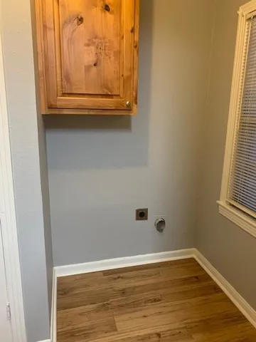 a view of a small space with wooden floor and a window
