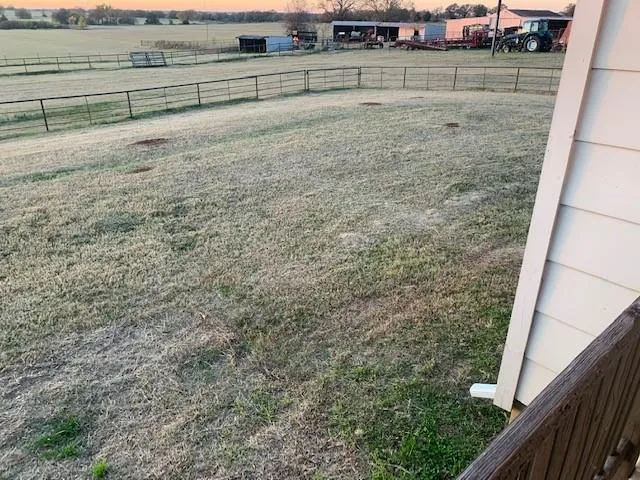 a view of a yard with wooden fence