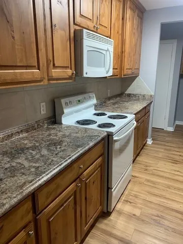a kitchen with stainless steel appliances granite countertop a stove a sink and a microwave