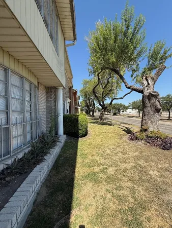a view of yellow house with wooden fence