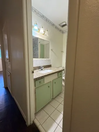a bathroom with a granite countertop sink and a mirror