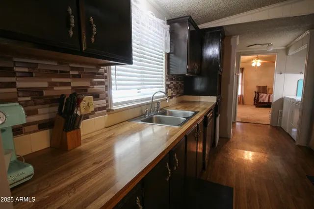 a kitchen with stainless steel appliances granite countertop a sink a stove and a wooden cabinets