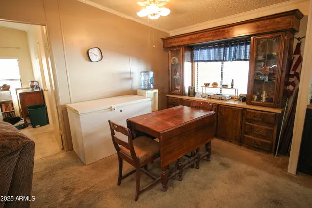 a room with a table chairs and a refrigerator