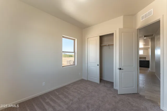 an empty room with windows and entrance to other room