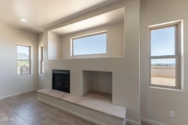 a view of an empty room with a window and fireplace