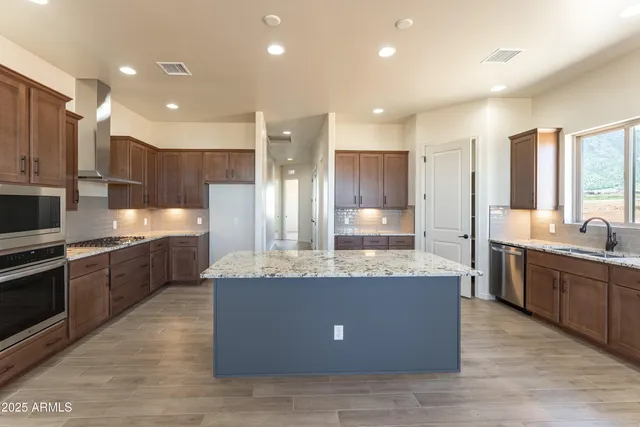 a large kitchen with stainless steel appliances kitchen island granite countertop a large counter top and stove