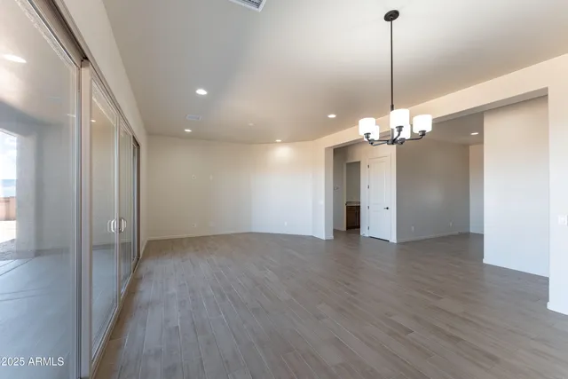 a view of a livingroom with a chandelier wooden floor and chandelier
