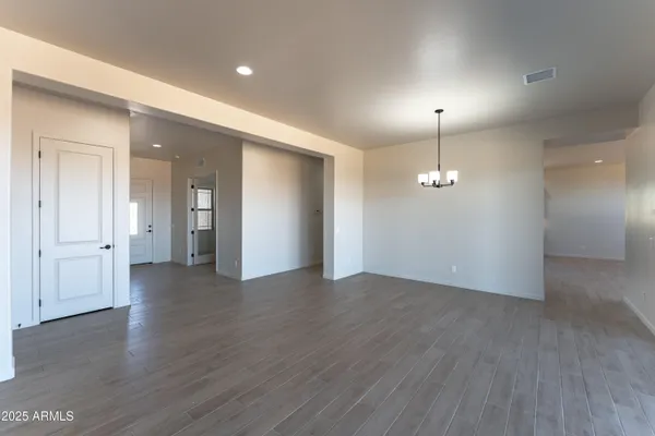 an empty room with wooden floor and mirror