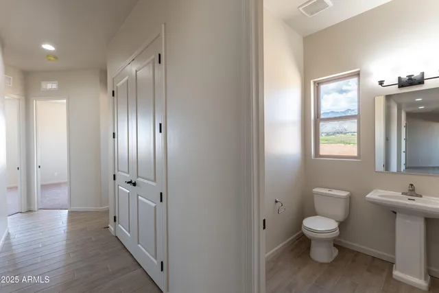 a bathroom with a toilet a sink and mirror