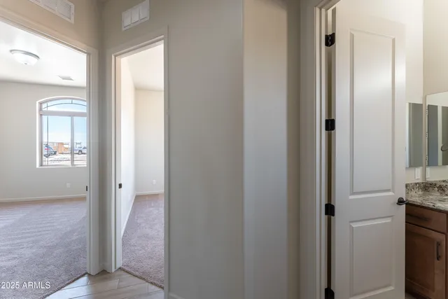 a view of a hallway with wooden floor and a livingroom