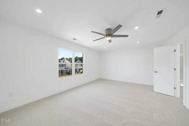 an empty room with windows and fan