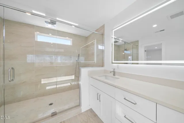 a bathroom with a granite countertop sink mirror and shower