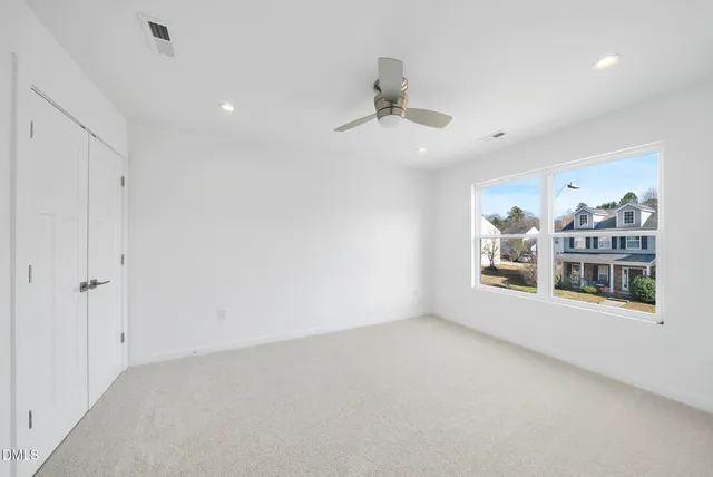 en empty room with window and ceiling fan