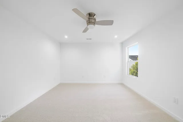 an empty room with a window and a ceiling fan