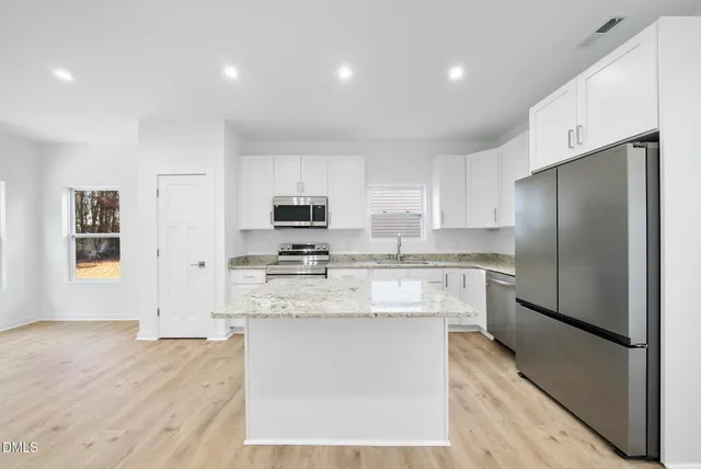 a kitchen with stainless steel appliances a refrigerator stove microwave and sink