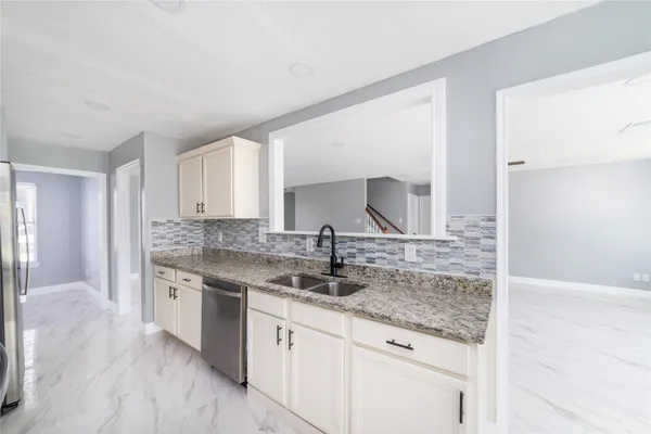 a kitchen with stainless steel appliances granite countertop a sink stove and cabinets
