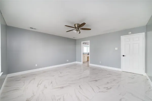 an empty room with fan and ceiling fan