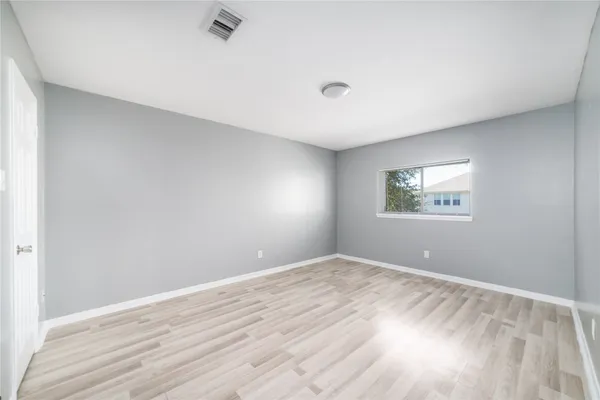 a view of empty room with wooden floor