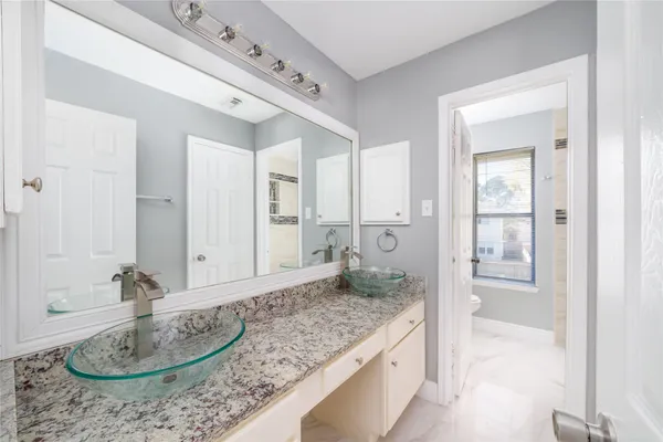 a bathroom with a granite countertop sink and a mirror