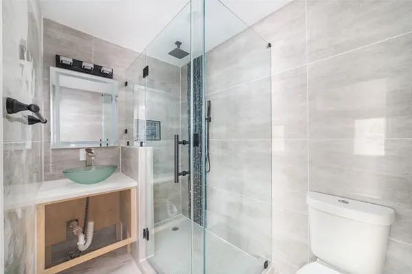 a bathroom with a granite countertop sink toilet and shower