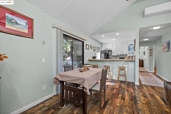 a living room with furniture a large window wooden floor and a rug