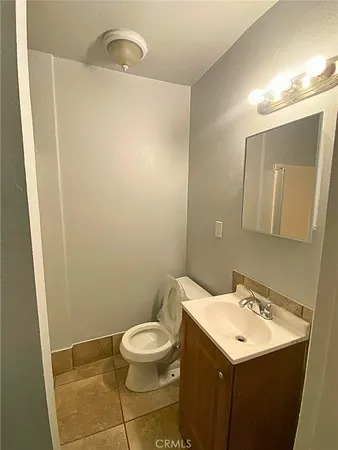 a bathroom with a sink mirror vanity and toilet