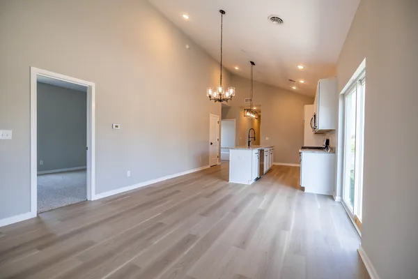 a view of a kitchen with wooden floor and a large window